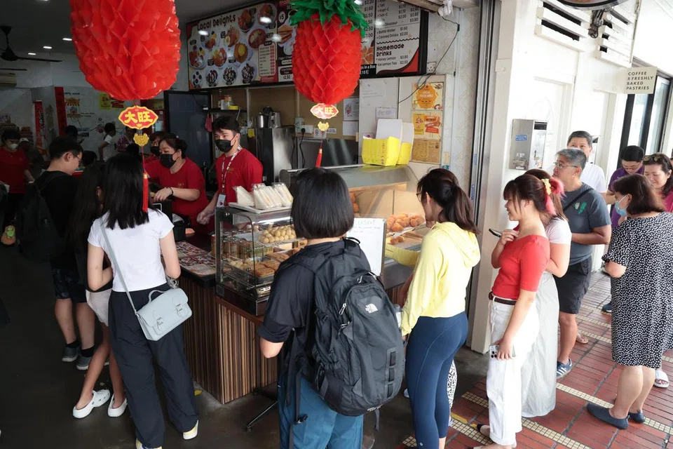 Atlet luncur lelayang Singapura, atau kitefoil, Maximilian Maeder, 18 tahun, mula menjual karipap seawal 7.30 pagi di Soon Soon Huat Curry Puff. Ramai peminat hadir membeli karipap yang dihidangnya.