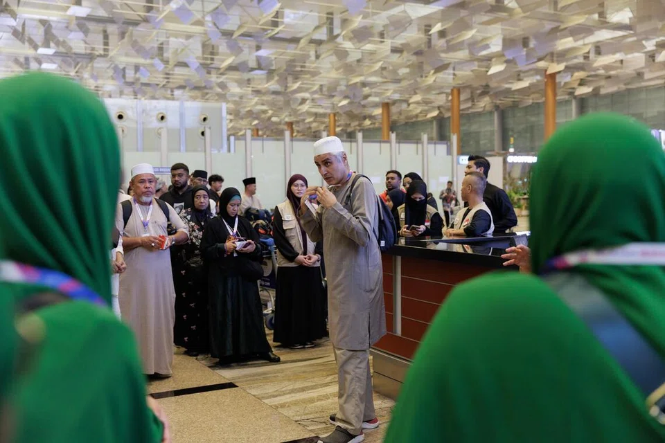 Jurubahasa isyarat, Encik Syed Muhammad Abdul Hamid, sedang memberi arahan dalam bahasa isyarat di Lapangan Terbang Changi pada malam 9 Oktober.