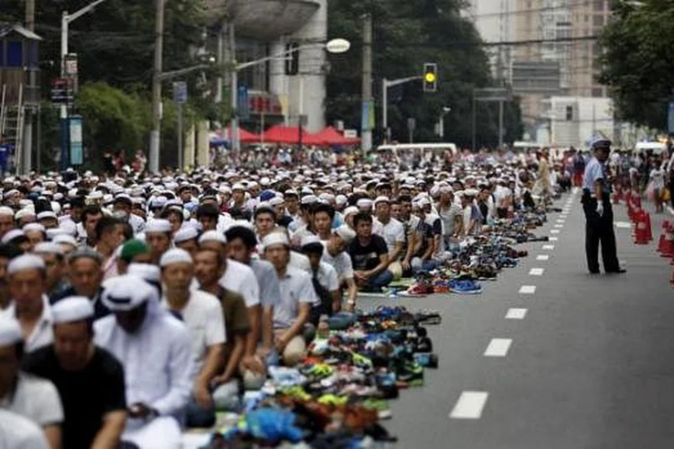TETAP BERSOLAT: Masyarakat Islam di Shanghai dibenarkan menunaikan solat Aidilfitri di sebatang jalan raya berhampiran sebuah masjid yang ditutup khas. - Foto REUTERS