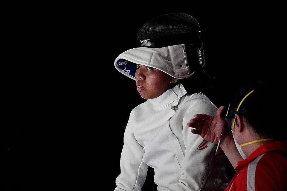TAK GENTAR ASAK JAGUH DUNIA: Kiria Tikanah (gambar atas, bersama jurulatih Henry Koh) menyerang atlet lawan pedang No 1 dunia dari Romania, Ana Maria Popescu, dalam acara epee perseorangan wanita di Dewan Makuhari Messe Hall pagi semalam. Popescu menang 15-10 selepas Kiria merapatkan skor 10-11 dengan baki 35 saat dalam perlawanan. - Foto AFP