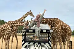 Cik Amira Rahmat melawat safari dan berinteraksi dengan zirafah di Thailand pada 2024.
