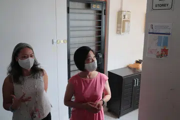 POSTER ANIMASI: Cik Carrie Tan (kiri) menerangkan kepada SMS Cik Sim Ann (kanan) poster animasi yang telah ditampal dengan harapan perokok akan elak merokok di tempat awam kerana terdapat kanak-kanak dan bayi di kawasan itu. - Foto BM oleh JASON QUAH.