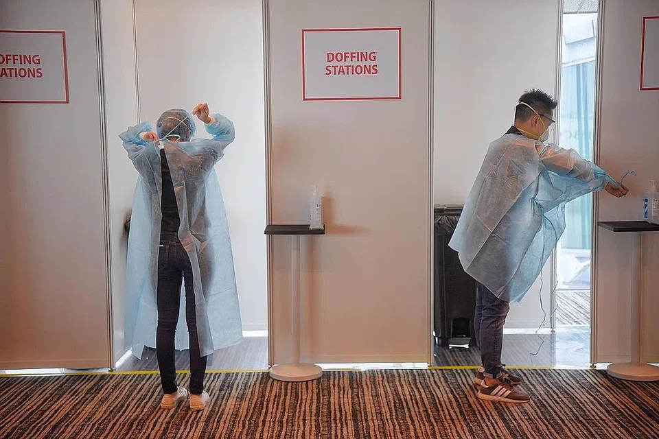 PERLU PAKAI PPE: Beberapa pekerja di zon berisiko tinggi sedang memakai Peralatan Perlindungan Peribadi (PPE) mereka di kemudahan yang disiapkan dekat kawasan rehat dan menjamu makanan. Semua pekerja yang bertugas di zon itu perlu memakai PPE pada setiap masa selain waktu makan dan berehat. - Foto BH oleh MARK CHEONG