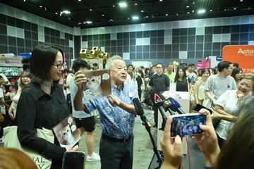 BERI PADANGAN: Encik Ng Kok Song bersama tunangnya, Cik Sybil Lau, menyertai pengunjung ke Ekspo Kucing Asia pada Sabtu di Pusat Konvensyen dan Pameran Suntec. 