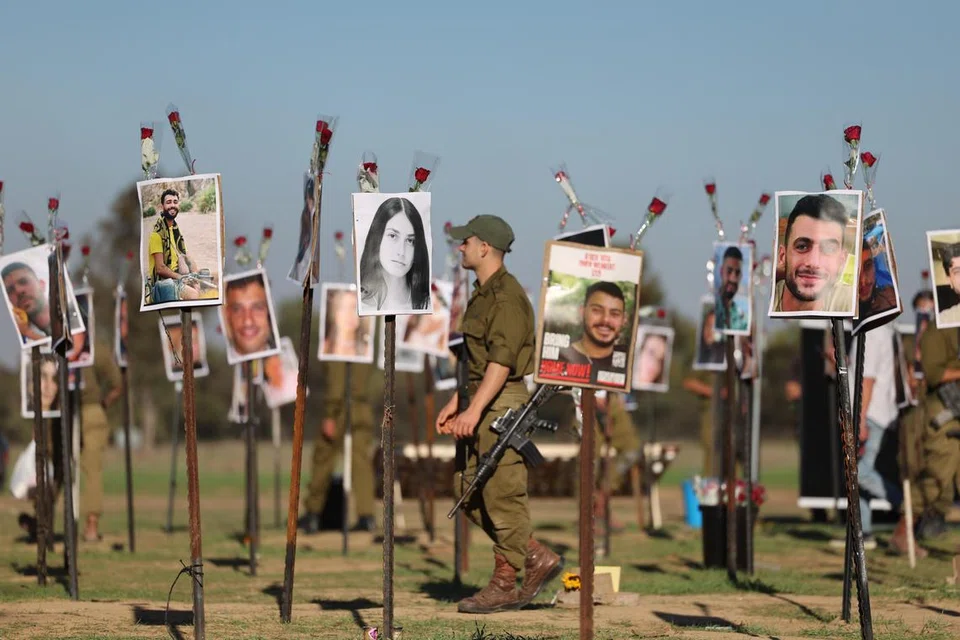 MEMORIAL: Askar Israel melihat gambar mangsa festival muzik Nova di tapak festival berhampiran Kibbutz Reim, berhampiran sempadan Gaza di selatan Israel, pada 29 November. Lebih 360 orang yang menghadiri festival itu terbunuh semasa serangan  Hamas pada 7 Oktober. 
