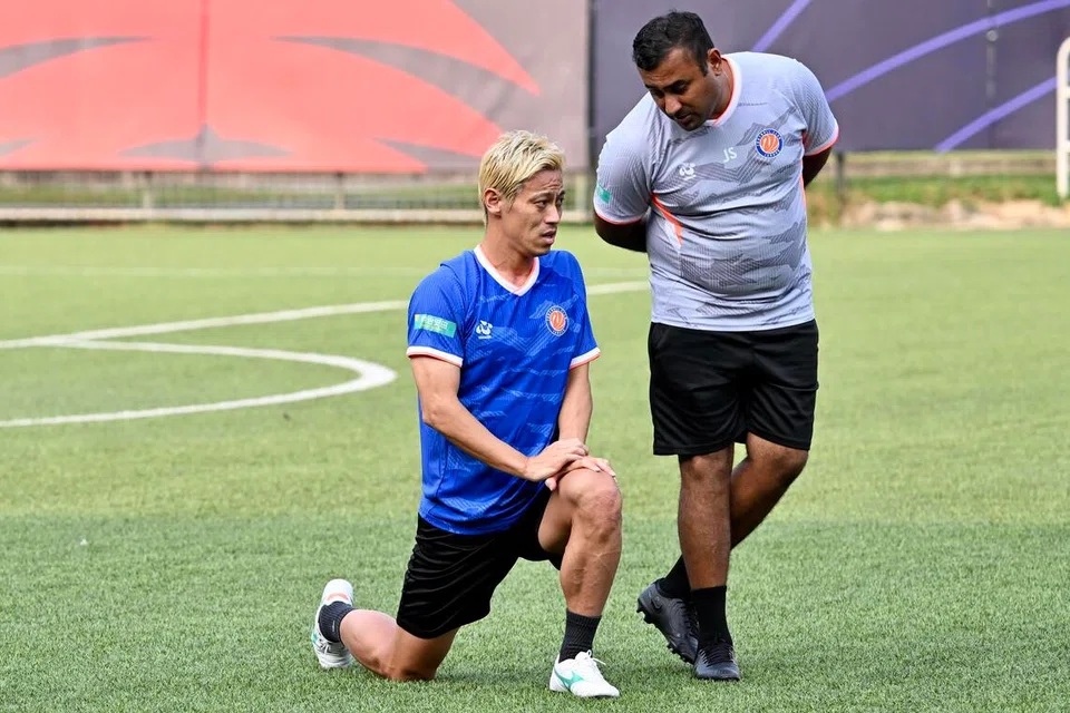 Jaswinder Singh (kanan) dan Keisuke Honda berbincang semasa sesi latihan FC Jurong di Stadium Jurong East pada 27 Ogos.
