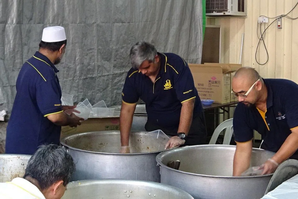 TRADISI MASJID: Para sukarelawan dari Masjid Khalid turut meringankan tangan membungkus nasi beriani sewaktu acara Cabaran Presiden kelmarin. - Foto ALLAUDIN MOHAMAD