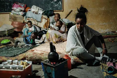 KEADAAN MEMILUKAN: Seorang wanita yang melarikan diri dari konflik di wilayah Tigray, Habsyah, sedang menyiapkan kopi untuk satu bilik darjah yang dipenuhi dengan 25 ibu yang berada di sekolah rendah Mekele, di ibu kota Tigray, sejak tujuh bulan lalu. Sekolah itu menjadi kem penempatan sementara untuk lebih 2,000 orang kebanyakannya dari Humura, bersempadankan dengan Eritrea dan Sudan. Menurut PBB, Tigray, wilayah barat laut itu menyaksikan kira-kira 350,000 di ambang kebuluran. - Foto AFP