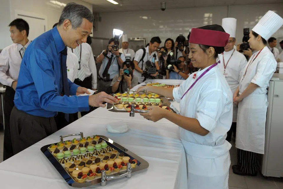 Perdana Menteri, Encik Lee Hsien Loong, mencuba pastri yang disediakan pelajar Institut Pendidikan Teknikal (ITE) semasa pembukaan rasmi kampus ITE Kolej West di Choa Chu Kang Grove pada 18 April 2011.