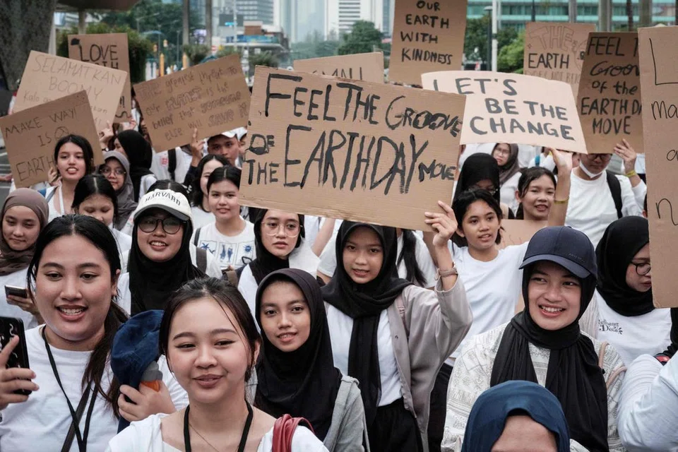 Warga negara Indonesia memegang sepanduk semasa perarakan menjelang Hari Bumi pada 22 April iaitu hari kesedaran alam sekitar tahunan, di Jakarta.