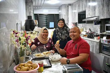 TEROKA USAHA NIAGA: Selain menjadi pekerja jagaan kesihatan dan perancang perkahwinan, Encik Mohd Nizard Ali (kanan), bintang Klik! cenderung mendalami bisnes epok-epok dari rumah sebagai membantu ibu mentuanya, Cik Saodah Abdul Rahman (tengah). Bersamanya ialah isterinya, Cik Nur Fakhirah Samat. - Foto BH oleh ARIFFIN JAMAR