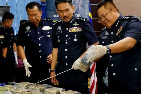 Pesuruhjaya Polis Sarawak, Datuk Mohamad Zainal Abdullah (tengah), melihat dadah yang dirampas pada sidang media di Ibu Pejabat Polis Kontinjen Sarawak pada 29 September.
