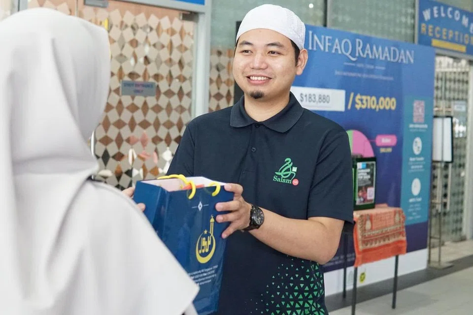 Ketua Jabatan yang juga Pegawai Kanan Dakwah Masjid, Jabatan Pendidikan dan Khidmat Masyarakat (Daerah Utara), Masjid An-Nur, Ustaz Muhammad Zuhaili Md Yusof (kanan), mengagihkan daging korban kepada seorang anggota jemaah wanita.