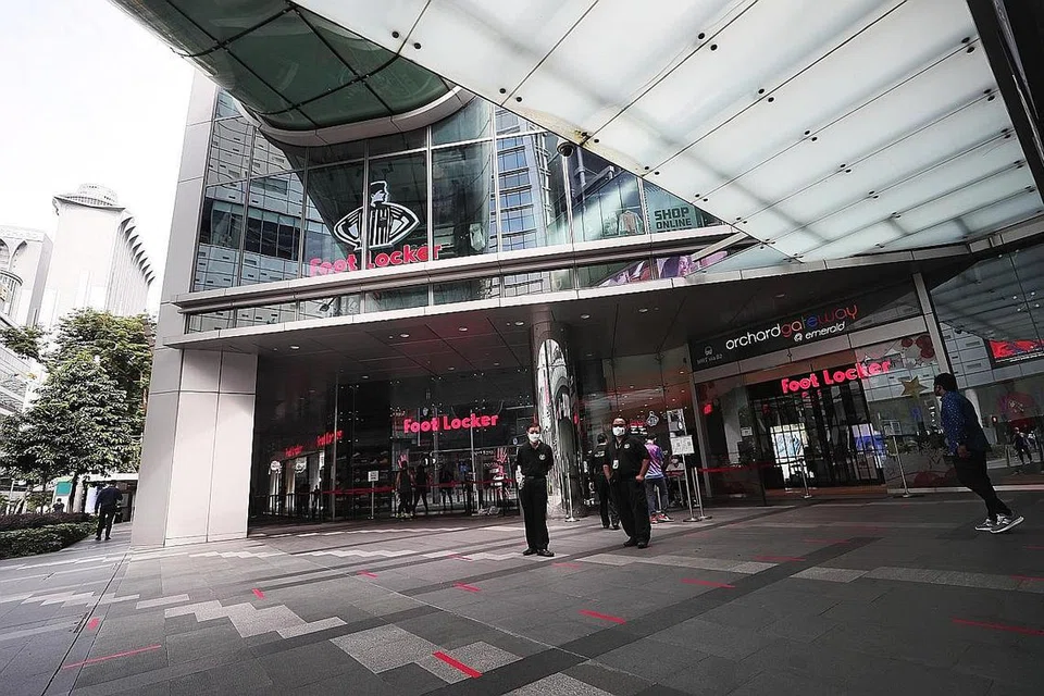 DIARAH TUTUP: Pegawai keselamatan dilihat di hadapan kedai Foot Locker di Orchard Gateway yang diarahkan menghentikan operasi selama 10 hari mulai semalam. - Foto BM oleh KELVIN CHNG