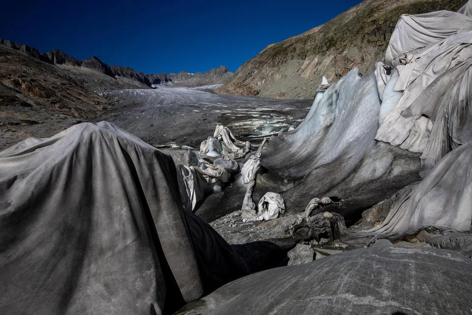 LINDUNGI AIS: Selimut digunakan untuk menutupi gua ais di glasier Rhone, di Obergoms, Switzerland, dalam usaha memperlahankan proses pencairan di tengah-tengah masalah perubahan iklim. Gambar diambil pada 26 September.