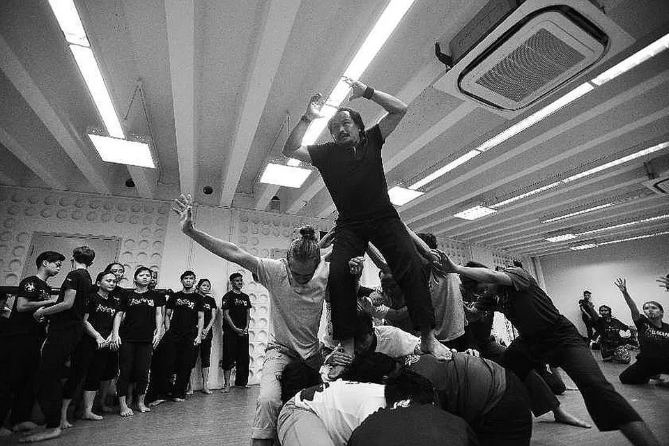 PERSEMBAHAN MENARIK: Dua penari yang membawa watak utama, Azmi Juhari (bertoncet) dan Azman Shariff (dijulang), menyertai penari lain membentuk pelbagai imej, misalnya bahtera, dalam teater 'Tumasik - Merungkai Semula Cerita Kita'. - Foto THEME VISUALS 