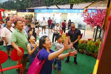 DAPAT "HONGBAO": Sempena Tahun Baru Cina ini, seramai 48 kanak-kanak menerima 'hongbao' sebanyak $20 dan beg 'goodie' daripada Dana Wang Saku Sekolah The Straits Times (STSPMF) kelmarin. Seletar Mall mengundang penerima dan keluarga mereka bergembira di pusat beli-belah itu. - Foto BH oleh GAVIN FOO