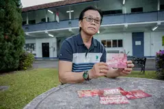 Encik Abdul Samad Abdul Kadir menatap wajah ibunya menerusi kepingan gambar-gambar lama yang dimiliki beliau.