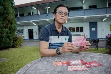 Encik Abdul Samad Abdul Kadir menatap wajah ibunya menerusi kepingan gambar-gambar lama yang dimiliki beliau.