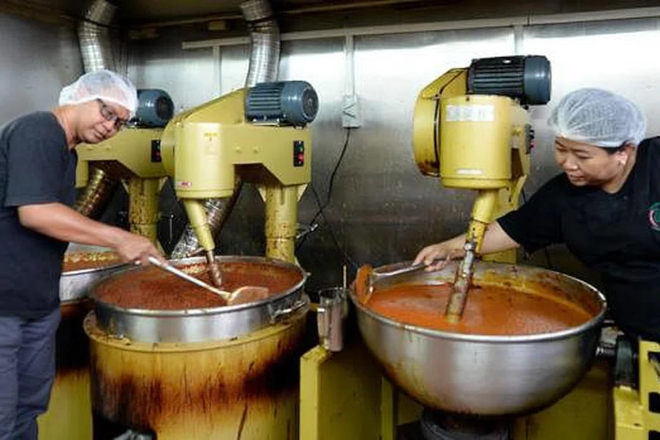 PELBAGAIKAN NIAGA: Encik Nor Hashim yang bergambar bersama isterinya, Cik Emilia melabur sekitar $18,000 dalam dua mesin pembancuh dan pembuat pes di kilangnya yang terletak di International Road. - Foto ZAINAL YAHYA