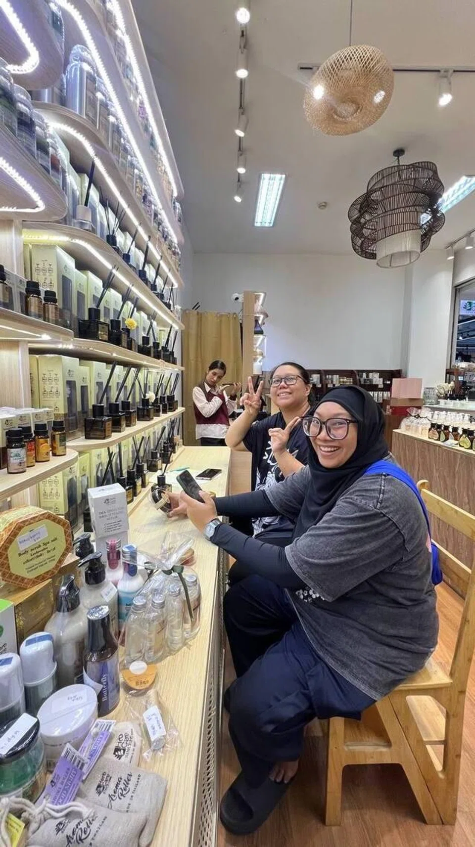 Pemilik hanaxsg, Cik Nooraini Mohamed Dahlan (dua dari kanan) bersama rakannya, Cik Nurul Aklin Mustafa di kedai minyak wangi di Indonesia. Cik Nooraini merupakan salah seorang pembeli peribadi dari Singapura yang mengambil pesanan pelanggan untuk membeli barangan di Jakarta dan Bandung.