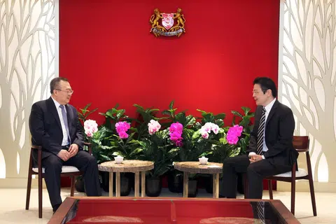 Encik Wong (kanan) dalam pertemuan dengan Encik Liu (kiri), di bangunan The Treasury pada 26 Mac. Encik Liu sedang mengadakan lawatan ke Singapura.