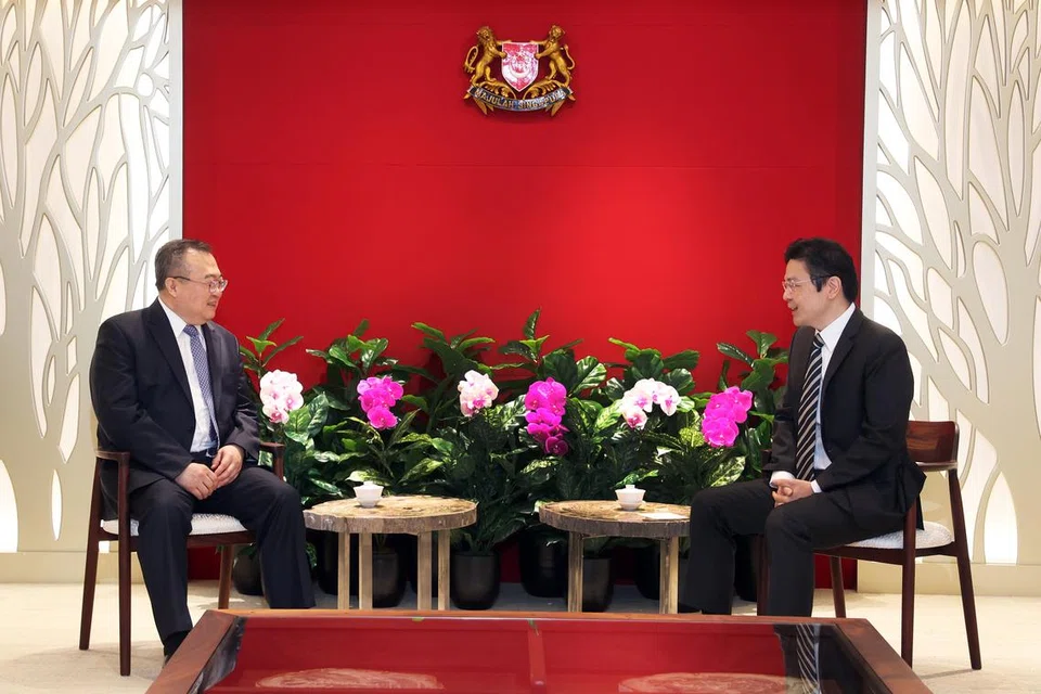 Encik Wong (kanan) dalam pertemuan dengan Encik Liu (kiri), di bangunan The Treasury pada 26 Mac. Encik Liu sedang mengadakan lawatan ke Singapura.