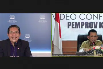 HULUR BANTUAN: Dr Mohamad Maliki Osman (kiri) dalam panggilan video bersama Gabenor wilayah Kepri, Encik Ansar Ahmad. Dalam panggilan video itu, Dr Maliki menyampaikan pakej bantuan daripada Pemerintah Singapura untuk menyokong usaha Kepri memerangi Covid-19. - Foto MFA