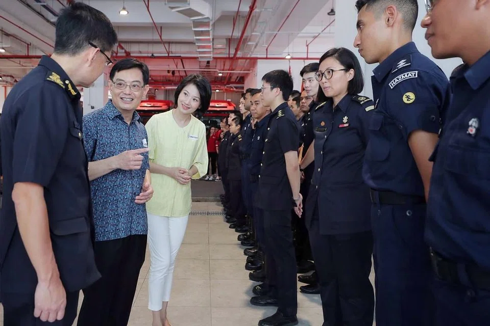 KERJA KERAS DIHARGAI: DPM Heng (dua dari kiri) yang ditemani Setiausaha Parlimen Kanan (Ehwal Dalam Negeri merangkap Pembangunan Negara), Cik Sun Xueling dan Pesuruhjaya SCDF Eric Yap (kiri), dengan atlit Team Singapore bertemu pegawai dari Balai Bomba Kallang semalam bagi melahirkan penghargaan ke atas peranan mereka menangani koronavirus . - Foto BH oleh GAVIN FOO 