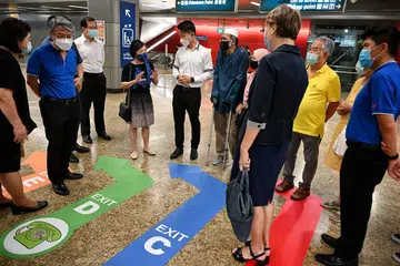 BOLEH CARI JALAN SENDIRI: Encik Baey (lima dari kiri, berkemeja putih) mendengar pandangan beberapa penumpang, termasuk Cik Emily Ong (empat dari kiri) dan Encik Rosli (enam dari kiri, berkopiah dan bertopang), semasa pelancaran inisiatif baru 'Find Your Way' di Stesen MRT Chinatown semalam. - Foto BH oleh KUA CHEE SIONG