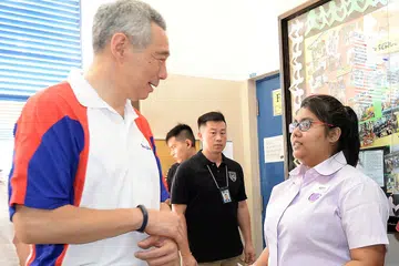 TAHNIAH!: Encik Lee mengucapkan tahniah kepada Cik Siti Nur Aslina yang merupakan penerima Anugerah Kemahiran Edusave pertama di divisyen Teck Ghee. - Foto ZAINAL YAHYA