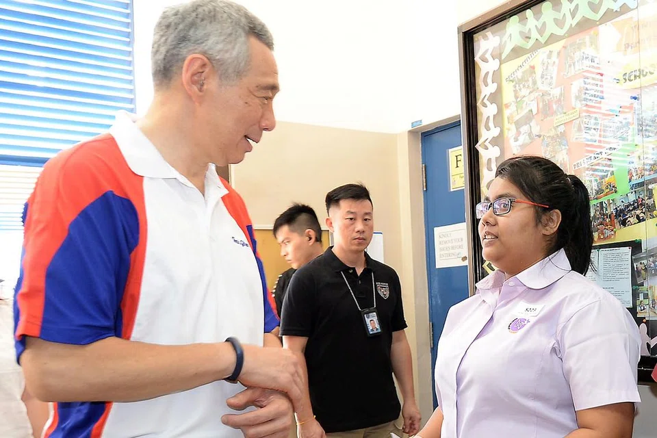 TAHNIAH!: Encik Lee mengucapkan tahniah kepada Cik Siti Nur Aslina yang merupakan penerima Anugerah Kemahiran Edusave pertama di divisyen Teck Ghee. - Foto ZAINAL YAHYA