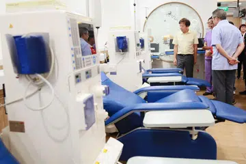 PUSAT DIALISIS BARU: Encik Khaw Boon Wan (kiri) meninjau dan mendengar penjelasan tentang mesin dialisis yang ditawarkan bagi pesakit ginjal di pusat dialisis The Hour Glass-NKF yang baru kelmarin. - Foto ZAOBAO