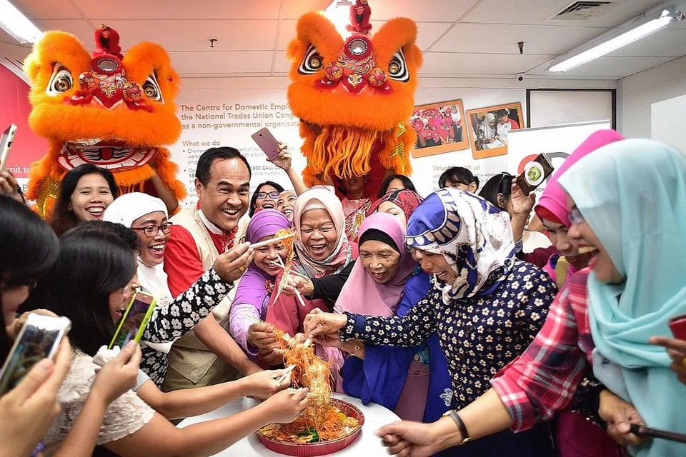 RAIKAN BERSAMA: Encik Shamsul (berbaju merah) bersama pembantu rumah asing ketawa riang melakukan sesi 'Lohei' bersama di CDE yang terletak di City Plaza semalam. - Foto BH oleh DESMOND WEE