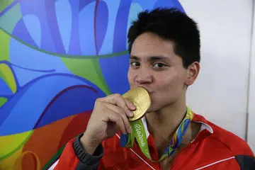 Joseph Schooling mencium pingat emas acara renang 100m kuak kupu-kupu yang dimenanginya di Sukan Olimpik Rio di Rio de Janeiro, Brazil, pada 13 Ogos 2016. 