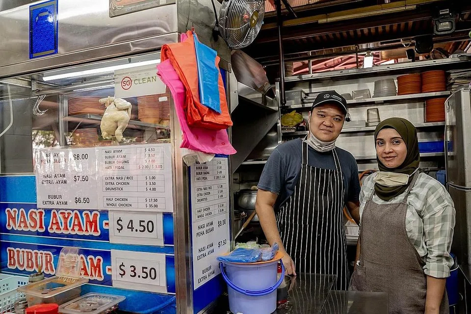 CUBA MENGEKALKAN HARGA: Pemilik gerai Geylang Serai Nasi Ayam Bubur Ayam, Encik Suhaimi dan isterinya, Zarina Muhammad Iqbal, baru-baru ini telah meningkatkan harga makanannya sebanyak 50 sen.