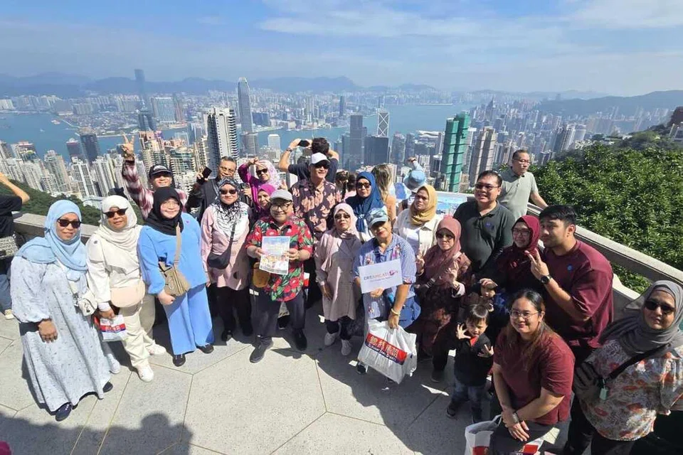 Cef Mel Dean (barisan depan, tengah) bergambar bersama rombongan di Sky Terrace 428, Menara Peak, Hong Kong, yang terletak pada ketinggian 428 meter dari paras laut. Ia merupakan platform tontonan tertinggi di bandar itu dan menawarkan pemandangan panorama yang menakjubkan.