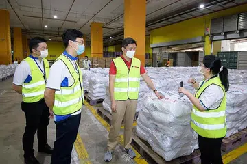 MEMASTIKAN BEKALAN STOK BERDAYA TAHAN: Encik Chan (dua dari kanan) mengunjungi kakitangan yang berusaha memperkukuh rantai bekalan Singapura menerusi kepelbagaian sumber dan penyimpanan stok makanan dan bekalan penting. - Foto FACEBOOK CHAN CHUN SING