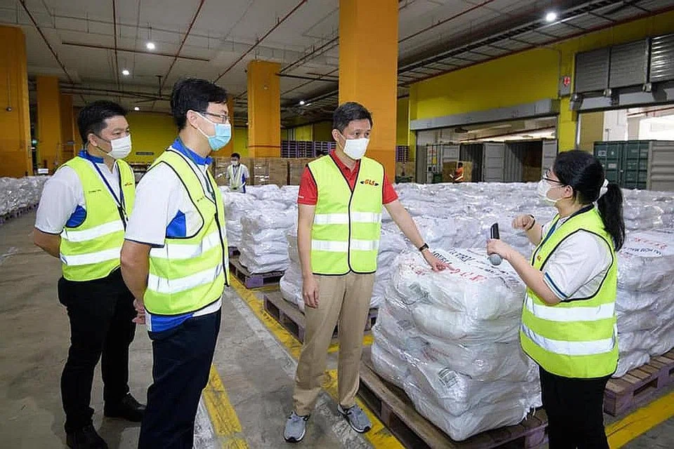 MEMASTIKAN BEKALAN STOK BERDAYA TAHAN: Encik Chan (dua dari kanan) mengunjungi kakitangan yang berusaha memperkukuh rantai bekalan Singapura menerusi kepelbagaian sumber dan penyimpanan stok makanan dan bekalan penting. - Foto FACEBOOK CHAN CHUN SING