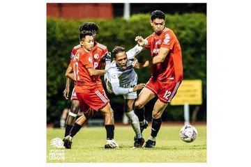 SEMANGAT CEKAL: Pemain Tampines Jordan Webb (tengah) hampir tersungkur semasa mengejar bola dan cuba meloloskan diri daripada perhatian pemain-pemain Balestier (jersi merah). Pemain Balestier menunjukkan kecekalan dan sifat tidak mahu kalah dalam perlawanan itu untuk bangkit menyamakan kedudukan selepas ketinggalan dua gol. - Foto SPL