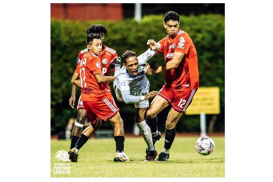 SEMANGAT CEKAL: Pemain Tampines Jordan Webb (tengah) hampir tersungkur semasa mengejar bola dan cuba meloloskan diri daripada perhatian pemain-pemain Balestier (jersi merah). Pemain Balestier menunjukkan kecekalan dan sifat tidak mahu kalah dalam perlawanan itu untuk bangkit menyamakan kedudukan selepas ketinggalan dua gol. - Foto SPL