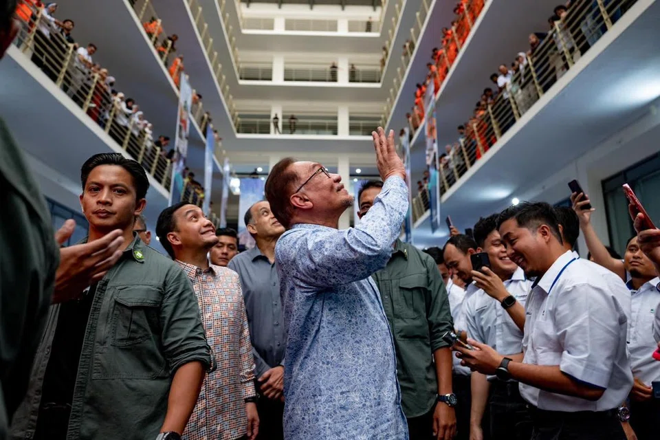 LAWATAN KERJA: Perdana Menteri Malaysia, Datuk Seri Anwar Ibrahim (tengah), melambai kepada kakitangan ketika melawat Pelabuhan Tanjung Pelepas (PTP) di Iskandar Puteri, Johor, pada 11 Januari.