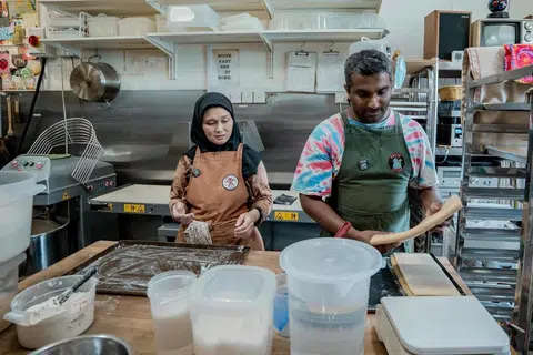 Pemilik Woodlands Sourdough, Cik Nurhasanah Johari dan Encik Chalith Kariyawasam sedang menyiapkan pelbagai jenis roti seperti roti sourdough dan croissant sourdough.