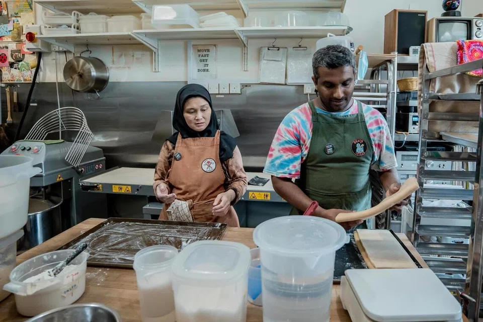 Pemilik Woodlands Sourdough, Cik Nurhasanah Johari, dan Encik Chalith Kariyawasam, sedang menyiapkan pelbagai jenis roti seperti roti ‘ourdough’ dan kroisan ‘sourdough’.