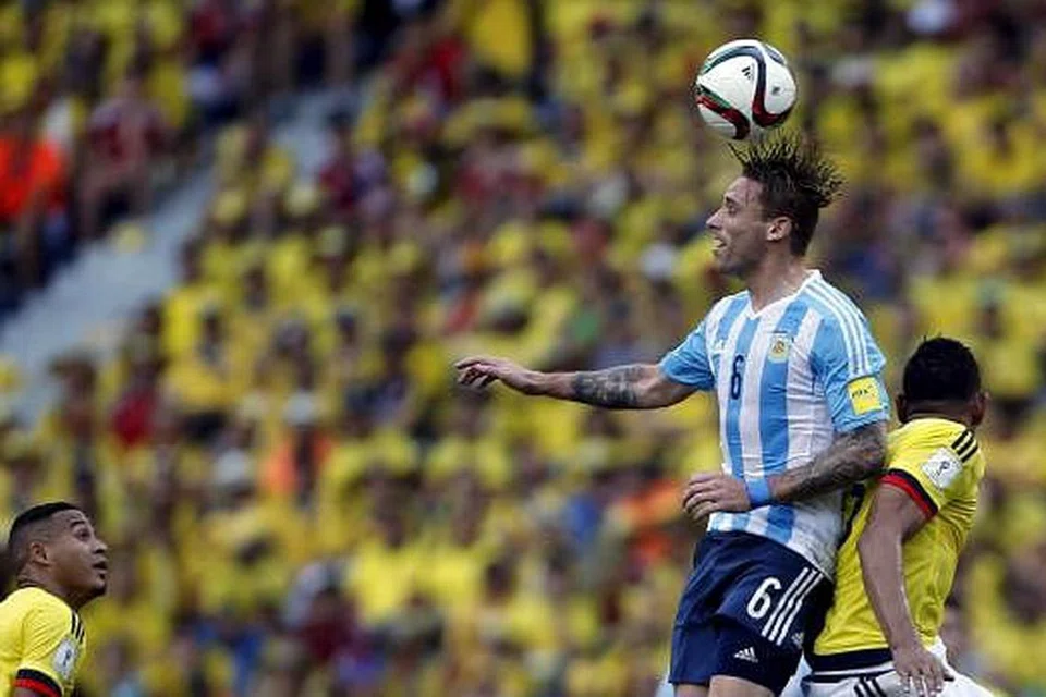 Penjaring gol Argentina, Lucas Biglia (jersi jalur-jalur), mendapat bola dalam perebutan dengan pemain Colombia, Alexander Mejia. Argentina menang 1-0 dalam perlawanan kelayakan Piala Dunia pada 17 November ini. Gambar REUTERS 