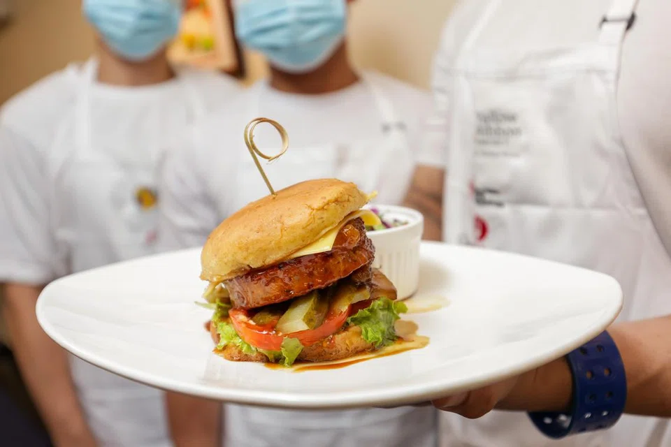 ANTARA PEMENANG: Salah satu pasukan pemenang Pertandingan Kulinari Reben Kuning dengan hidangan mereka, burger teriyaki Hawaii.