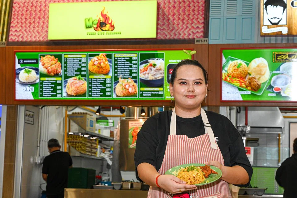 Pemilik M+ Fried Rice Paradise, Cik Siti Nurnameera Abdul Samad, membuka gerai nasi goreng yang dimasak dengan menggunakan mesin khas di Pusat Penjaja Woodleigh Village. 