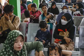 Orang ramai menunggu pemeriksaan kesihatan semasa bermulanya program pemeriksaan kesihatan percuma di sebuah pusat kesihatan masyarakat di Depok, Jawa Barat, pada 10 Februari.