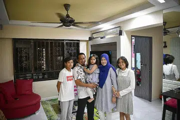 DEMI ANAK YANG MEMBESAR: Cik Nur Hafizah (dua dari kanan), suaminya, Encik Farin Ahmad, dan anak-anaknya - (dari kiri) Syed Qusyairi, Nur Armel Qaisarah dan Shariffah Qistina, akan berpindah ke flat lebih besar.