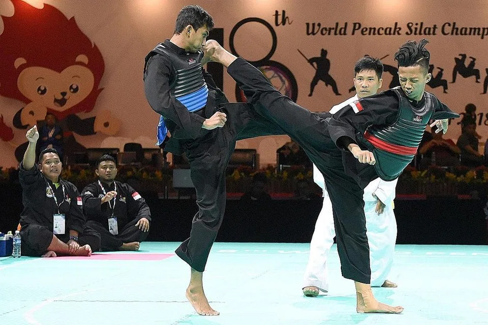 BAKAT MUDA MENYERLAH: Pada usia 17 tahun, Muhammad Hazim Mohd Yusli merupakan salah seorang pesilat negara yang dinobatkan juara dunia dalam kategori tanding - di samping Sheik Farhan Sheik Alau'ddin, Sheik Ferdous Sheik Alau'ddin, Nurul Suhaila Mohd Saiful - selepas mempamerkan keunggulannya dalam pertarungan Kelas B (50-55 kilogram). Dalam gambar kiri ini, kelihatan Muhammad Hazim (kanan) menewaskan pesilat Thailand, Patiwat Mont, dalam pusingan suku akhir, sebelum beliau mara ke peringkat separuh akhir dan akhir sebelum ditabal juara dunia. - Foto PERSISI